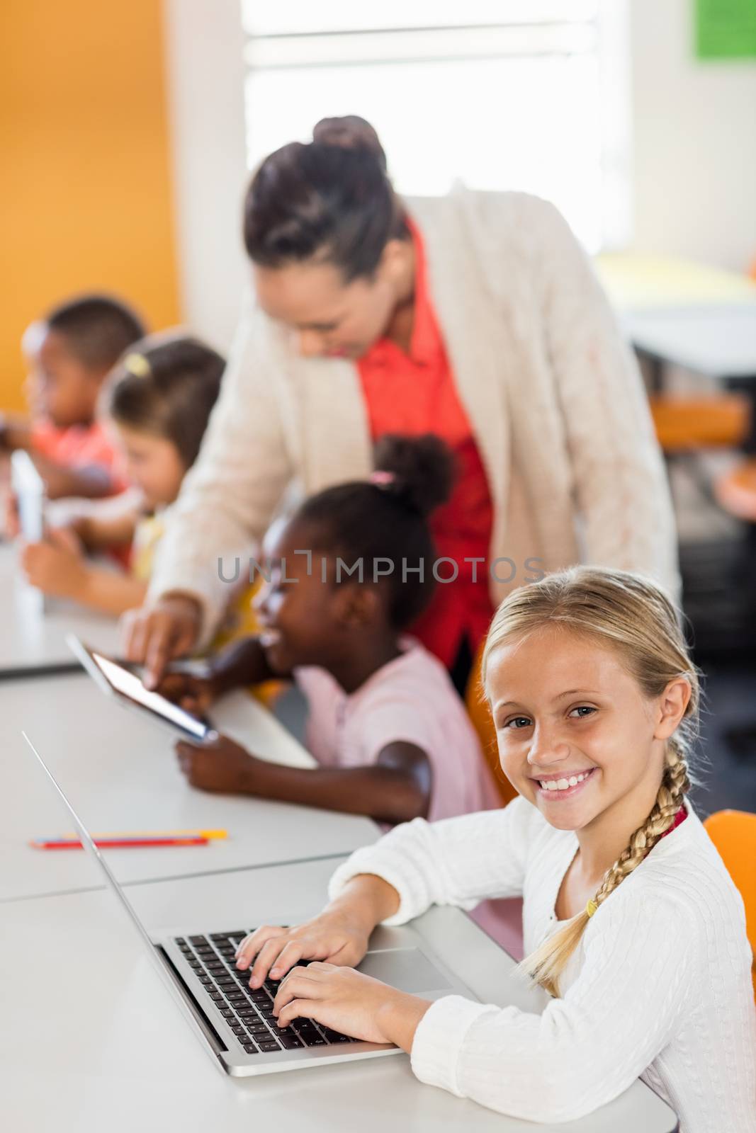 Teacher giving lesson to her students with technology at school