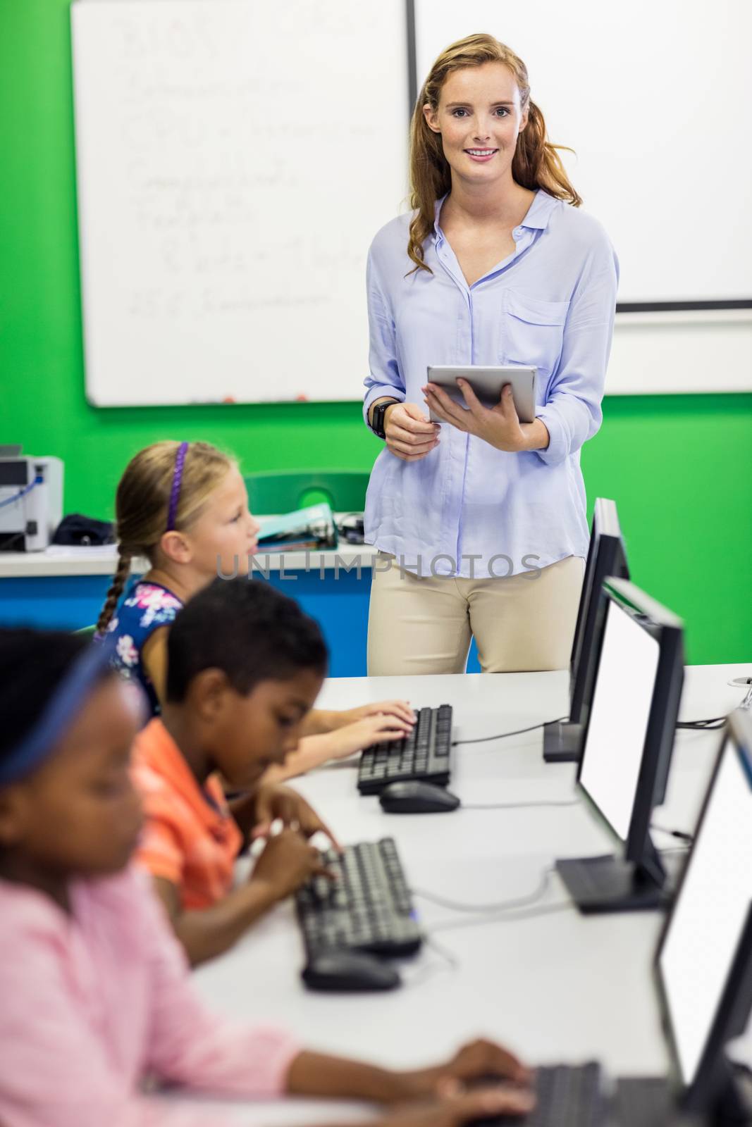 Teacher giving lesson to her students with technology by Wavebreakmedia