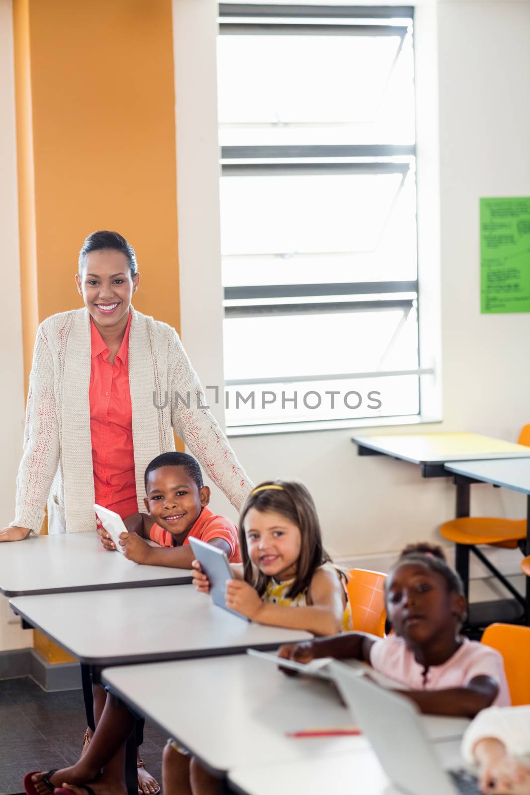 Teacher giving lesson to her students with technology by Wavebreakmedia