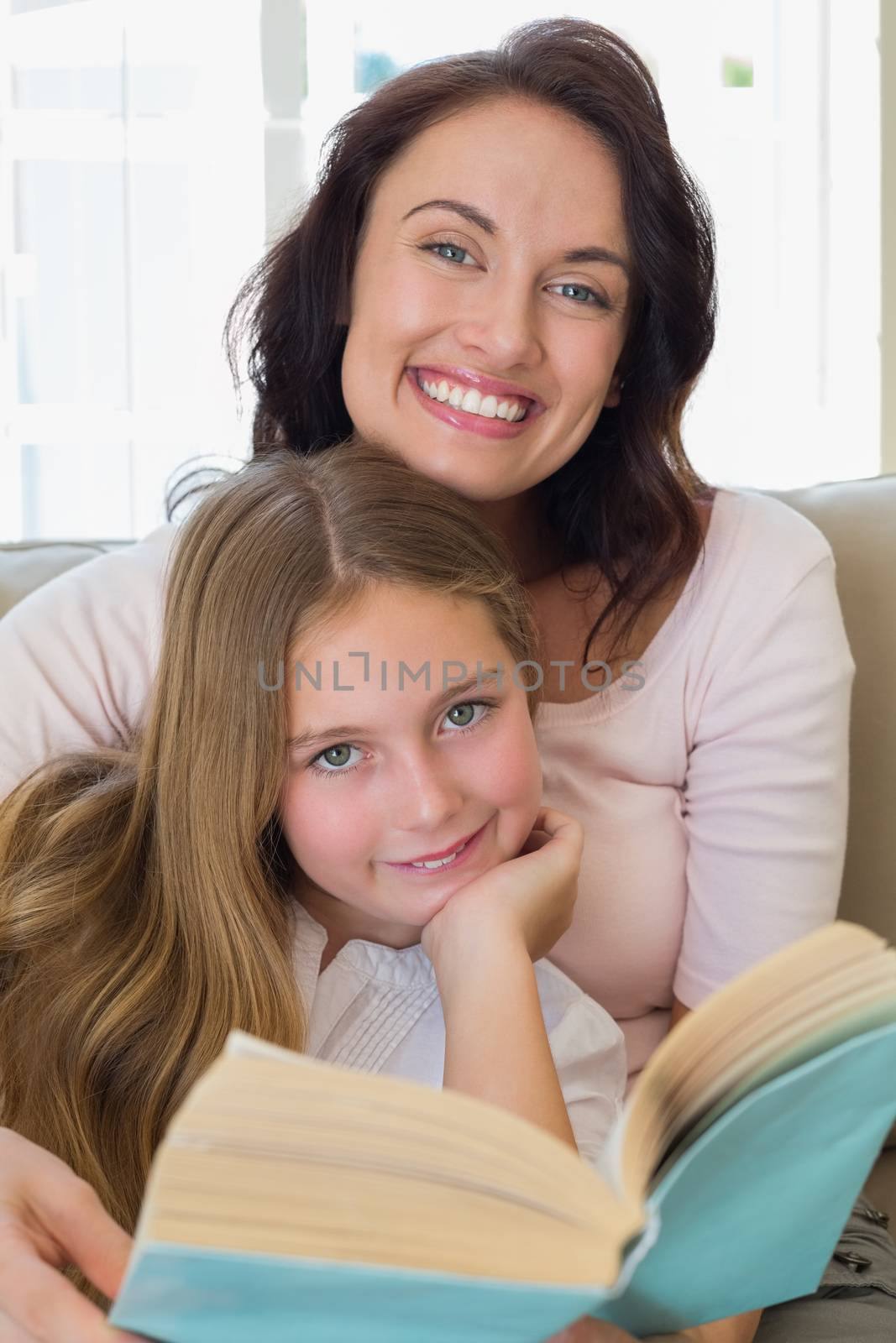 Portrait of woman and daughter with book at home