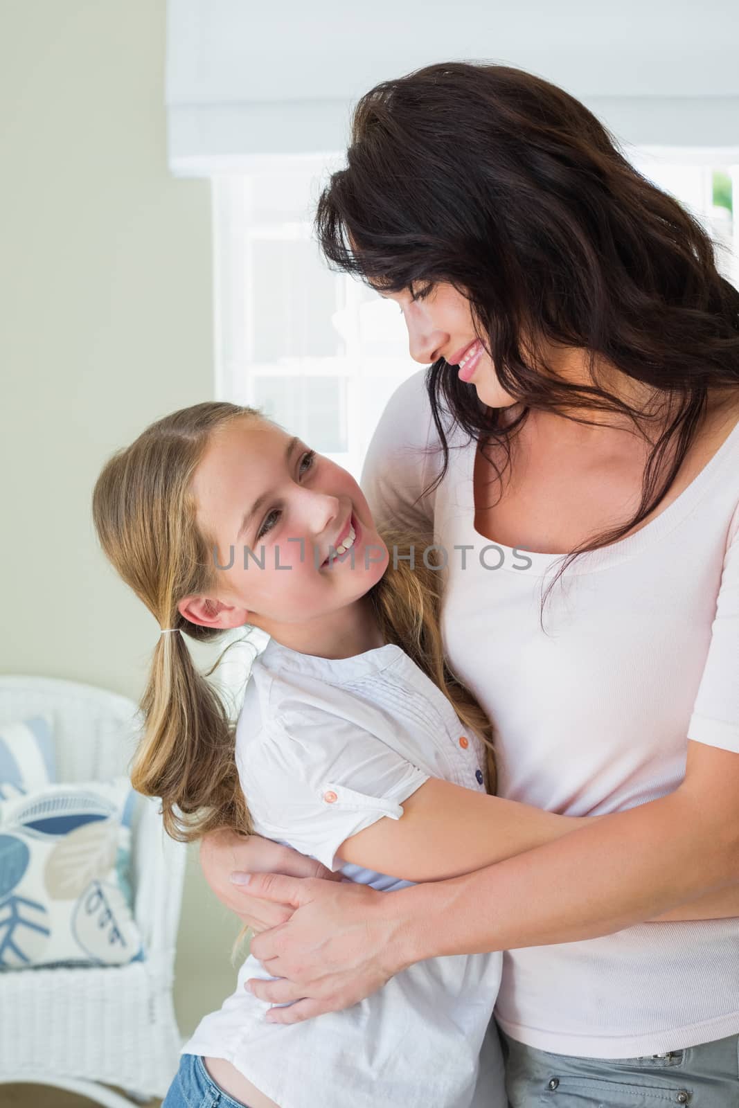 Happy daughter embracing mother in house