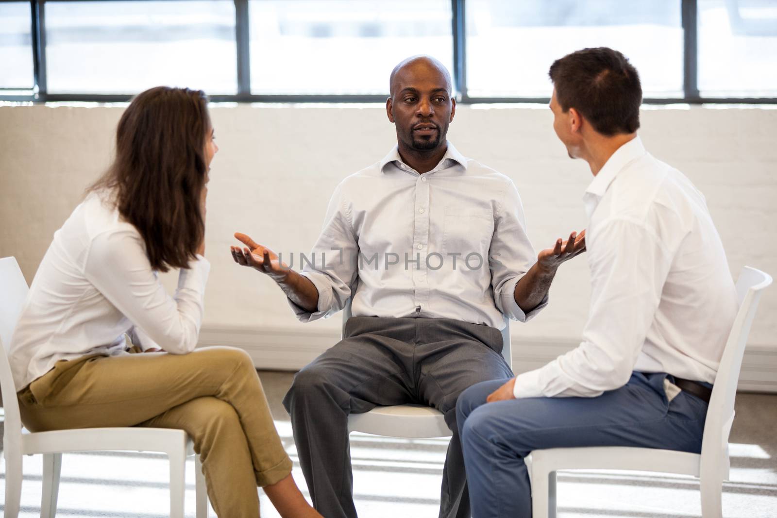 Business people having a discussion while sitting in modern studio