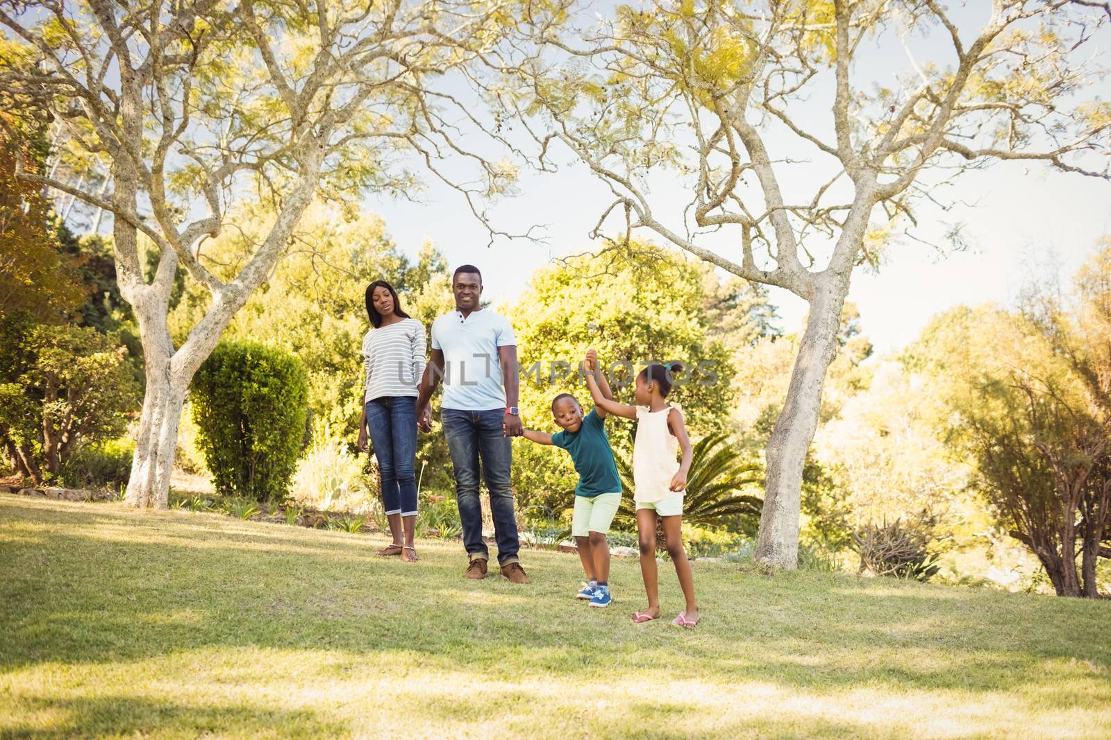 Happy family walking together at park 