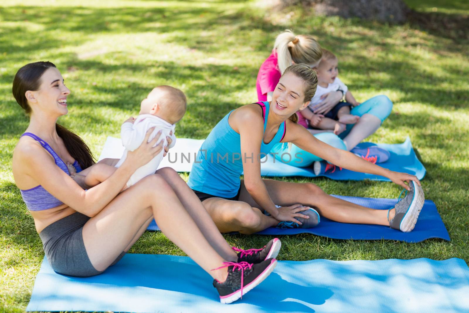 Women holding their babies while exercising  by Wavebreakmedia