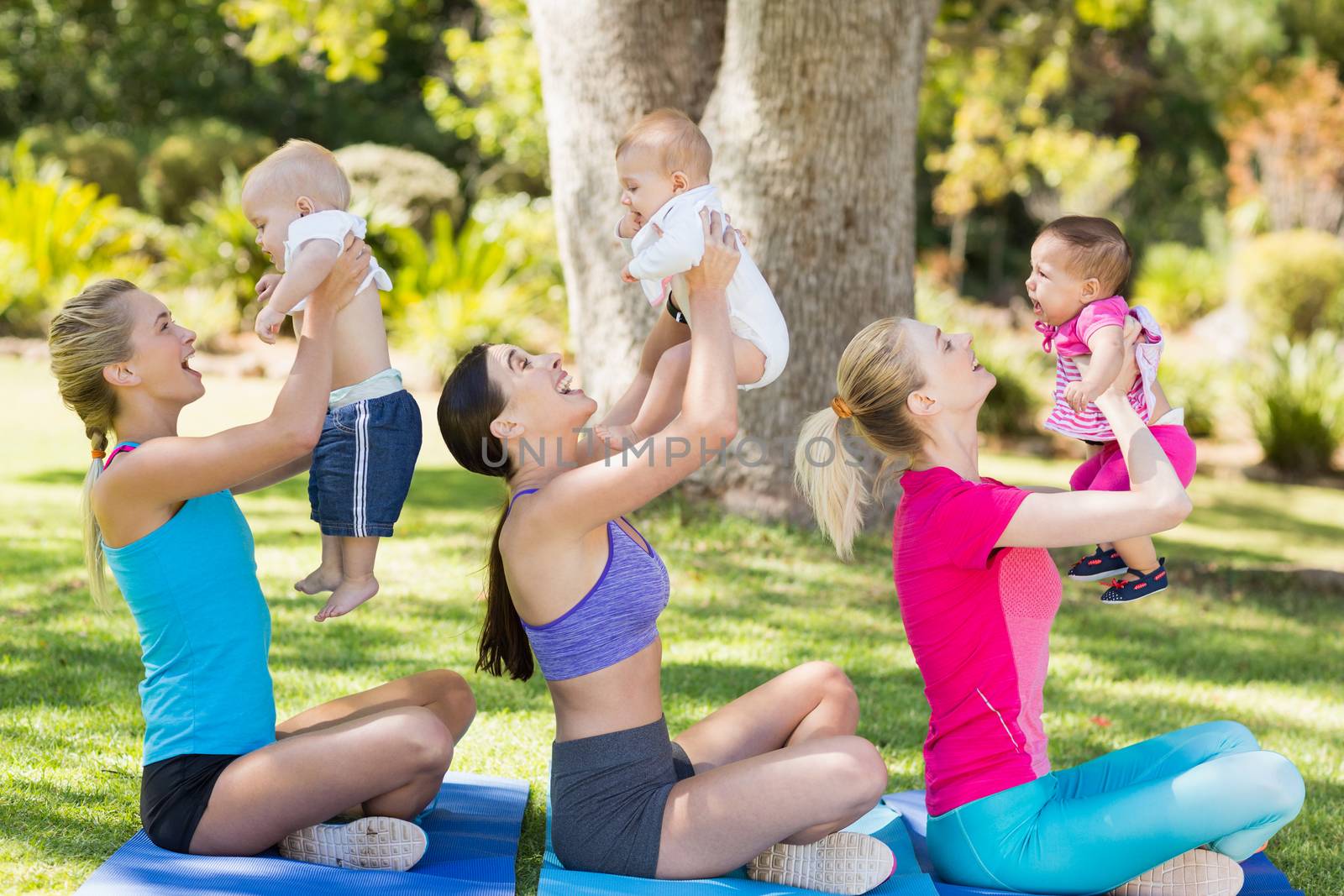 Women holding their babies while exercising by Wavebreakmedia