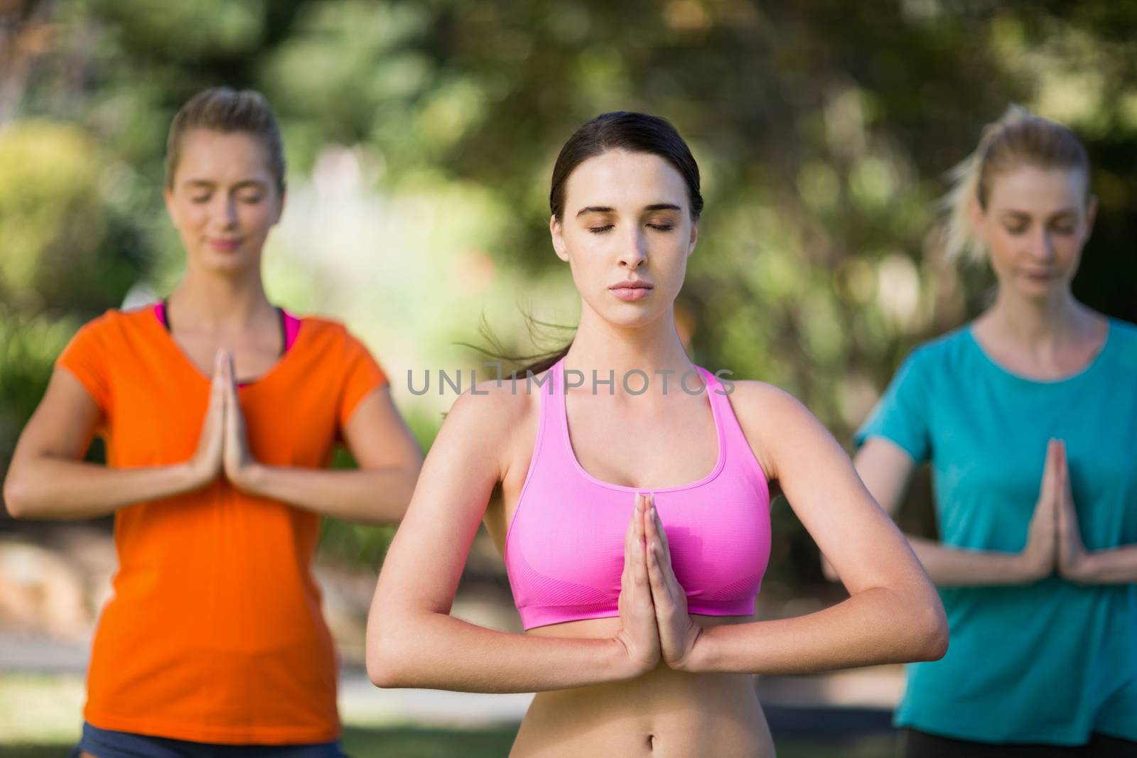 Women practicing yoga in park