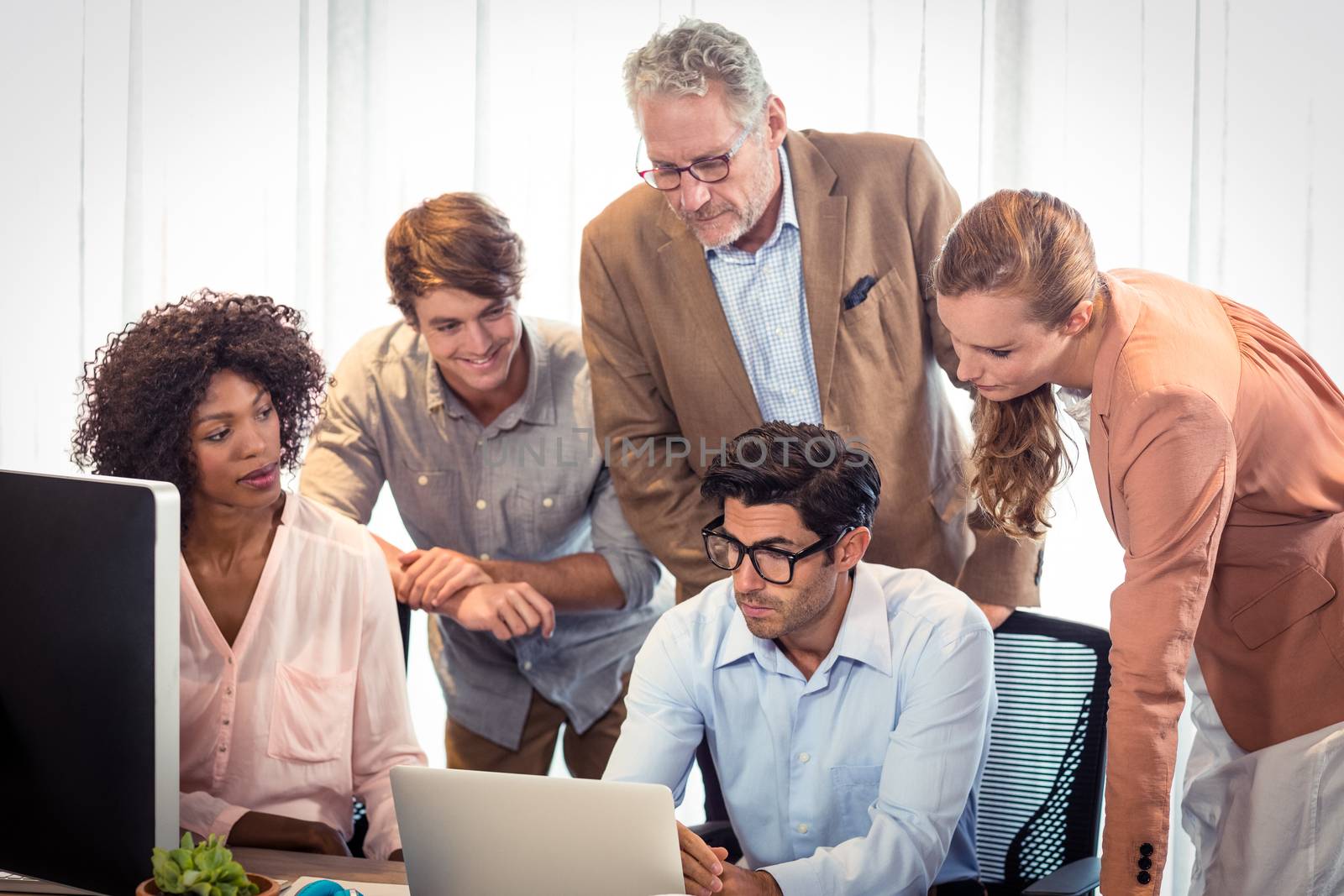 Business people discussing over laptop in office