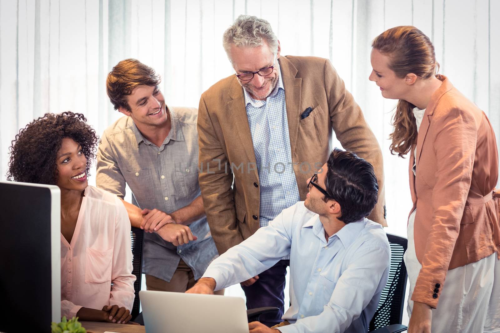 Business people discussing over laptop in office