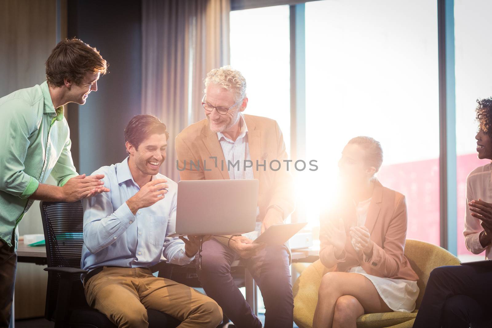 Business people discussing over laptop in office