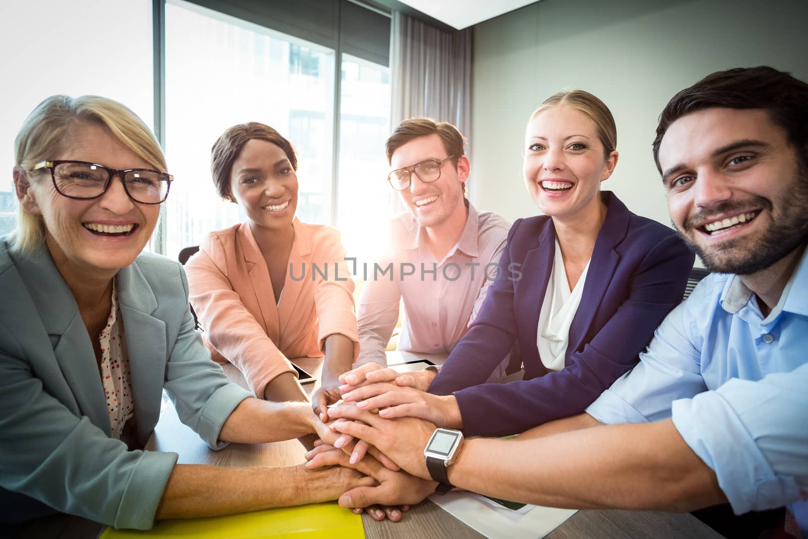 Portrait of business people with hand stacked during meeting in the office