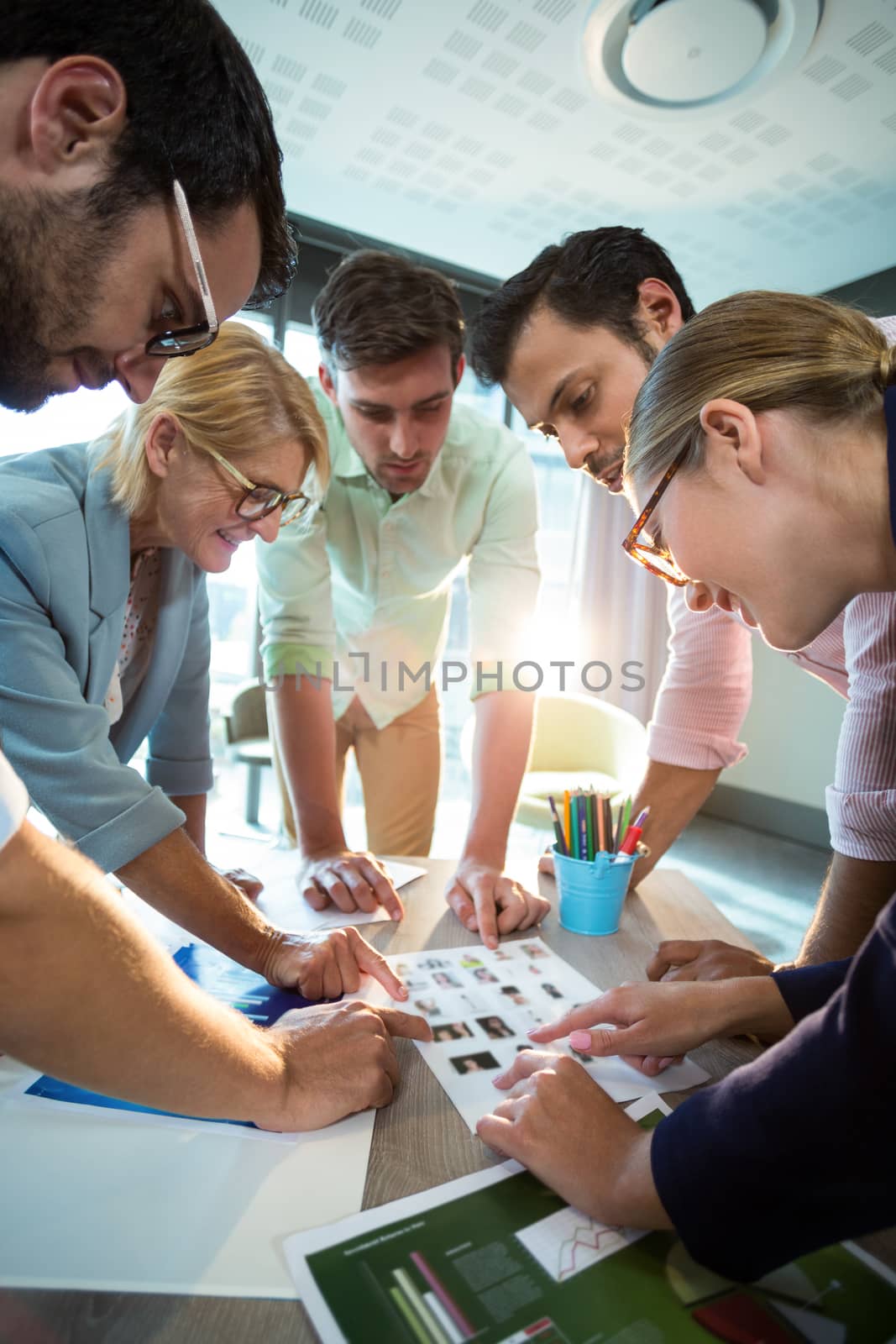 Business people discussing over photograph during a meeting by Wavebreakmedia