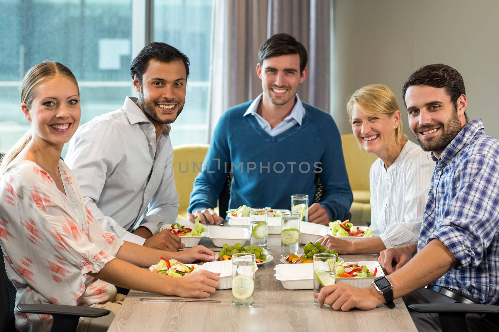 Portrait of business people having breakfast in the office