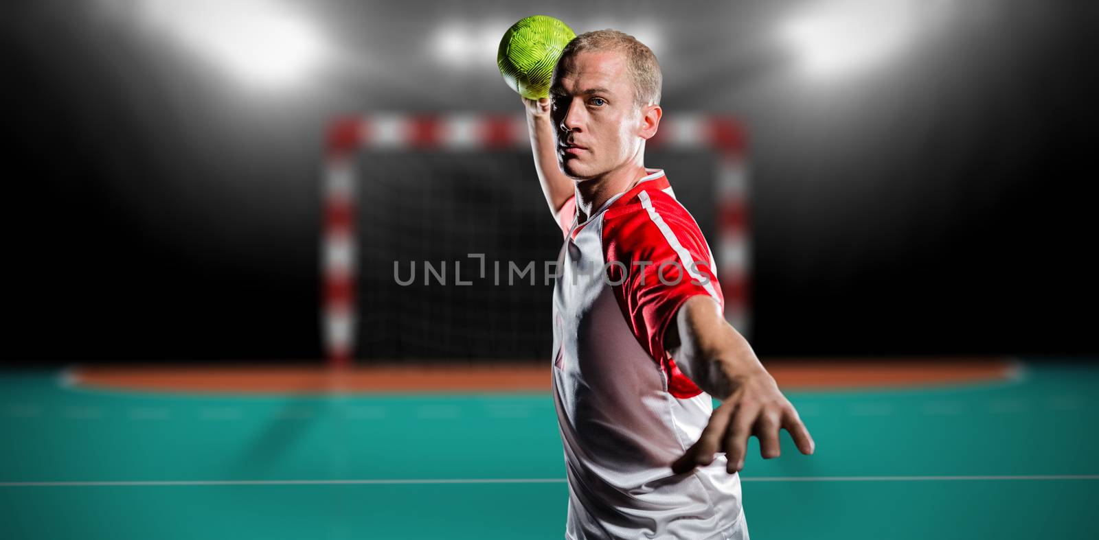 Sportsman throwing a ball against handball field indoor 