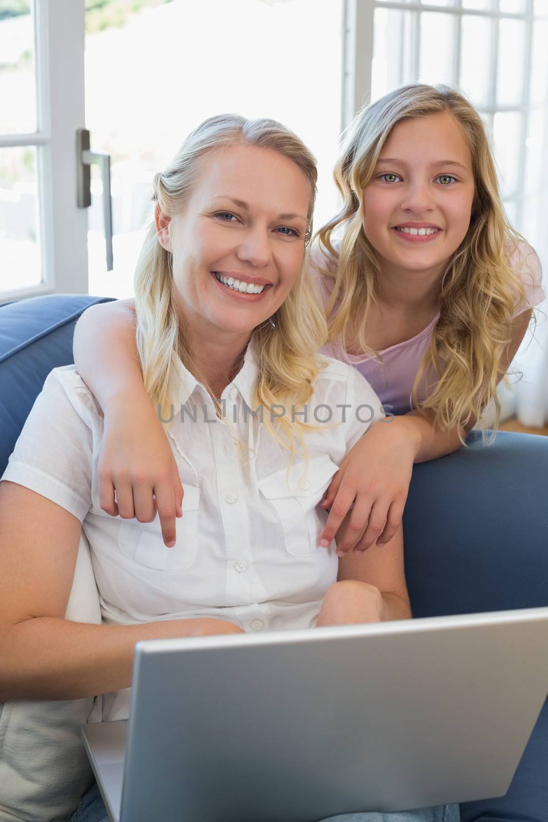 Happy mother and daughter with laptop in house by Wavebreakmedia