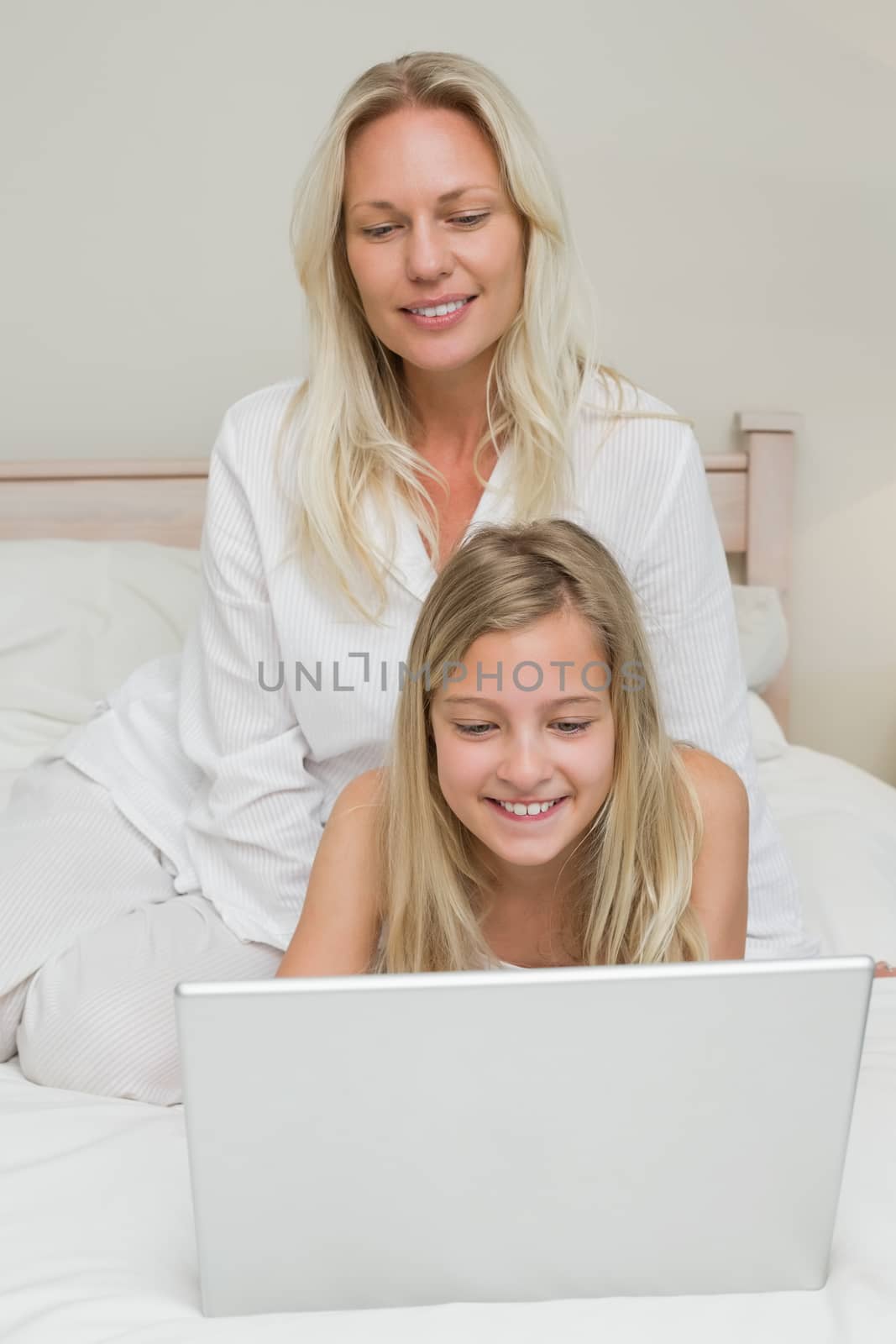 Girl using laptop while mother looking at it by Wavebreakmedia