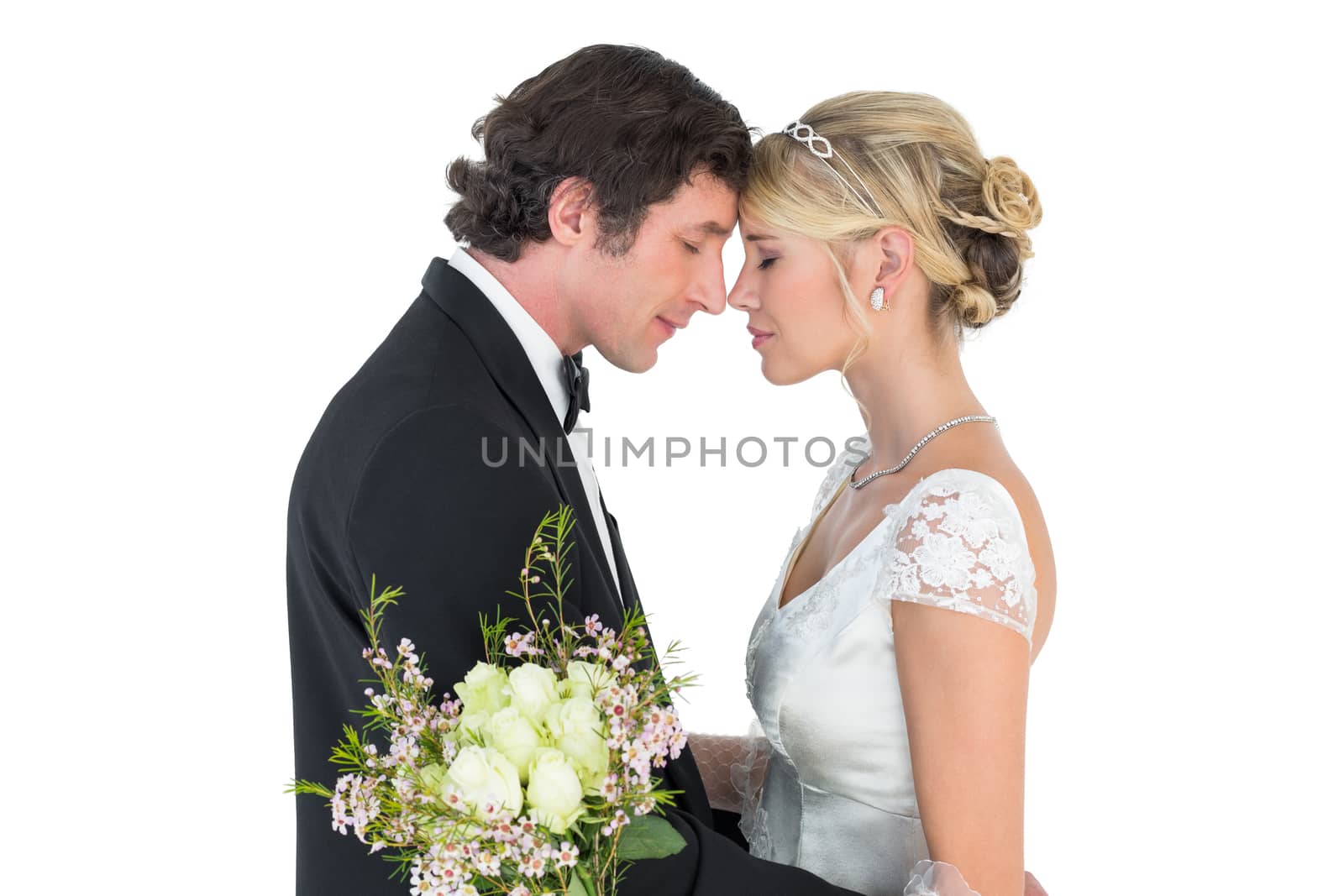 Side view of romantic couple standing head to head on white background