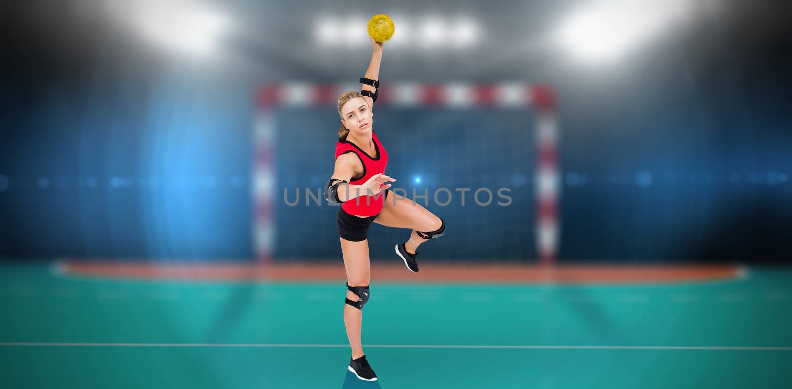 Female athlete throwing handball against handball field indoor 