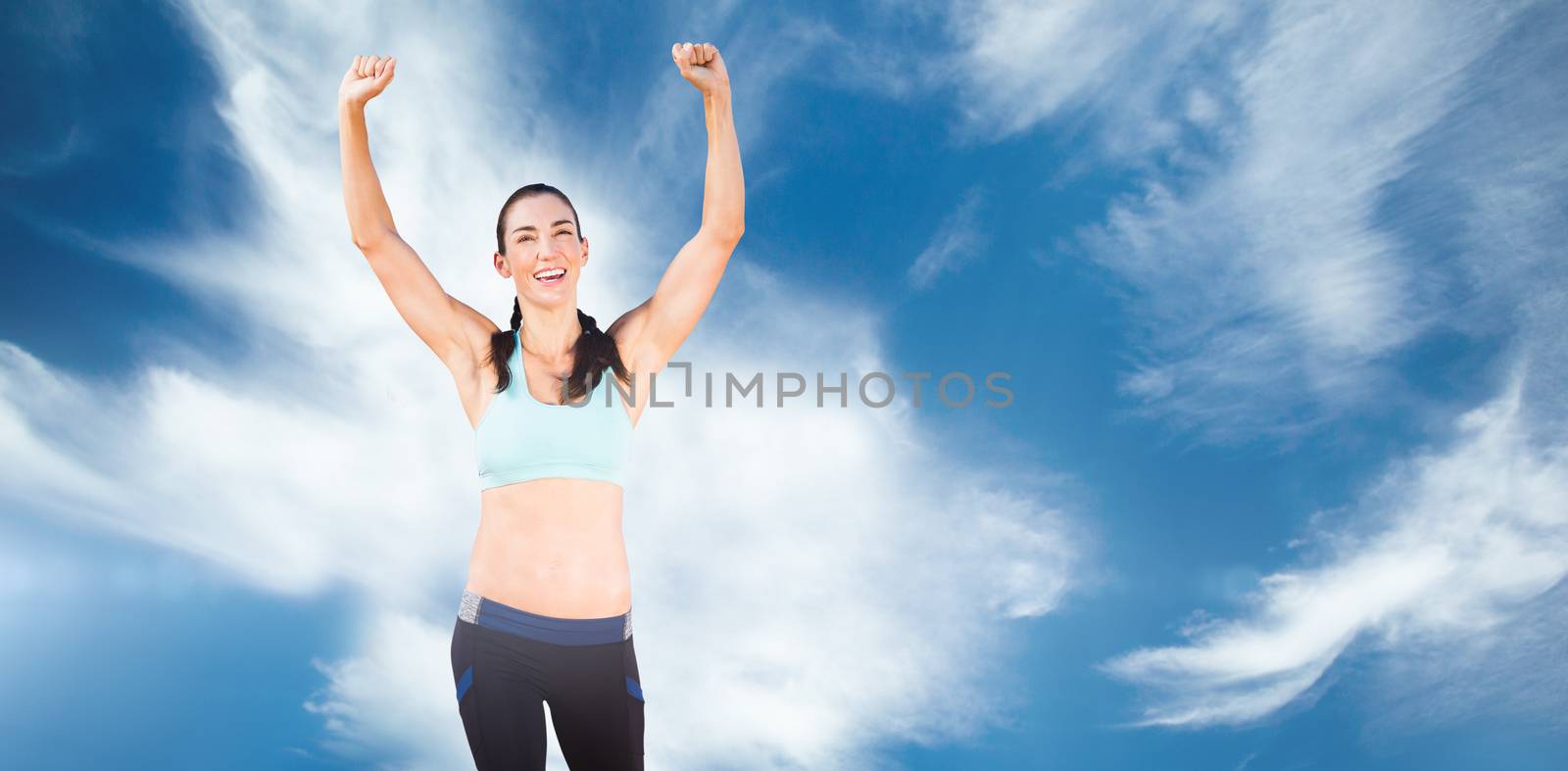 Sporty woman raising her arms against blue sky with clouds