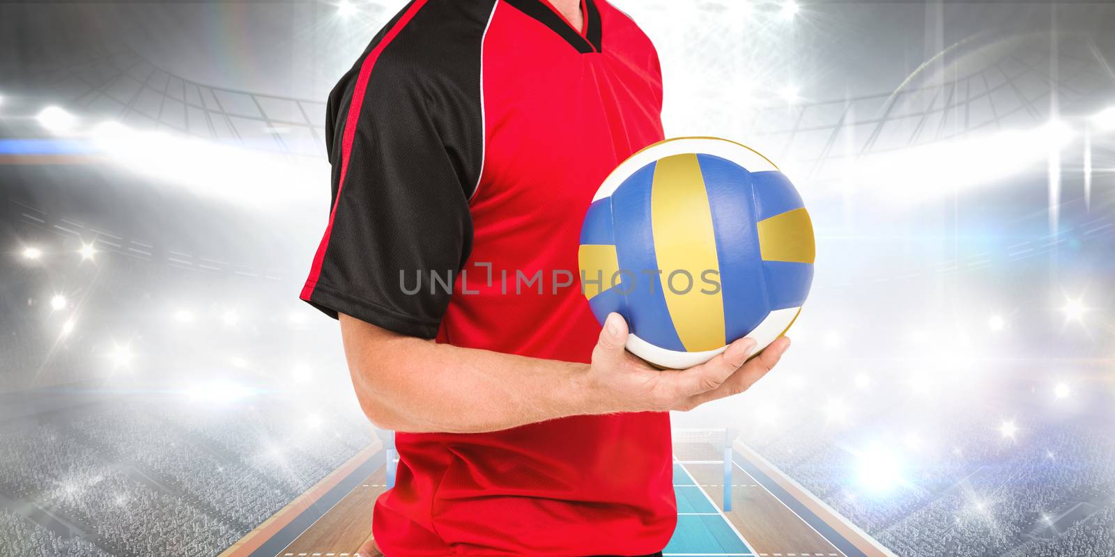 Sportsman holding a volleyball against view of a volleyball field