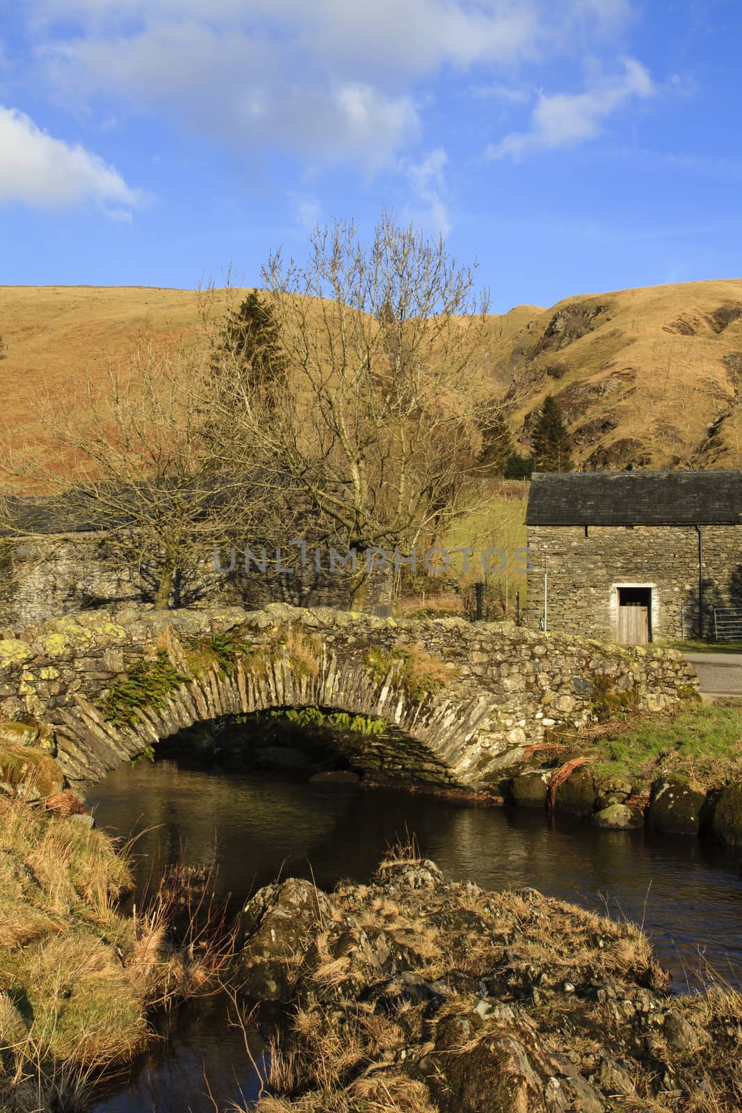 The stone packhorse bridge crossing Watendlath Beck is situated in Watendlath, Cumbria above Derwentwater in the English Lake District National Park.