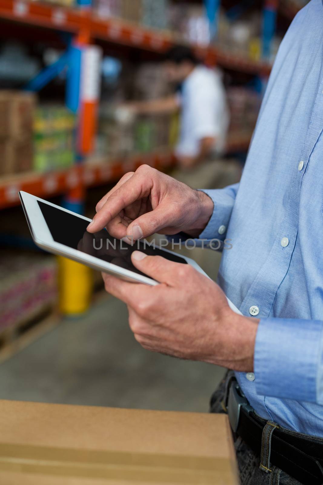 Close up of manager hands using a tablet in a warehouse