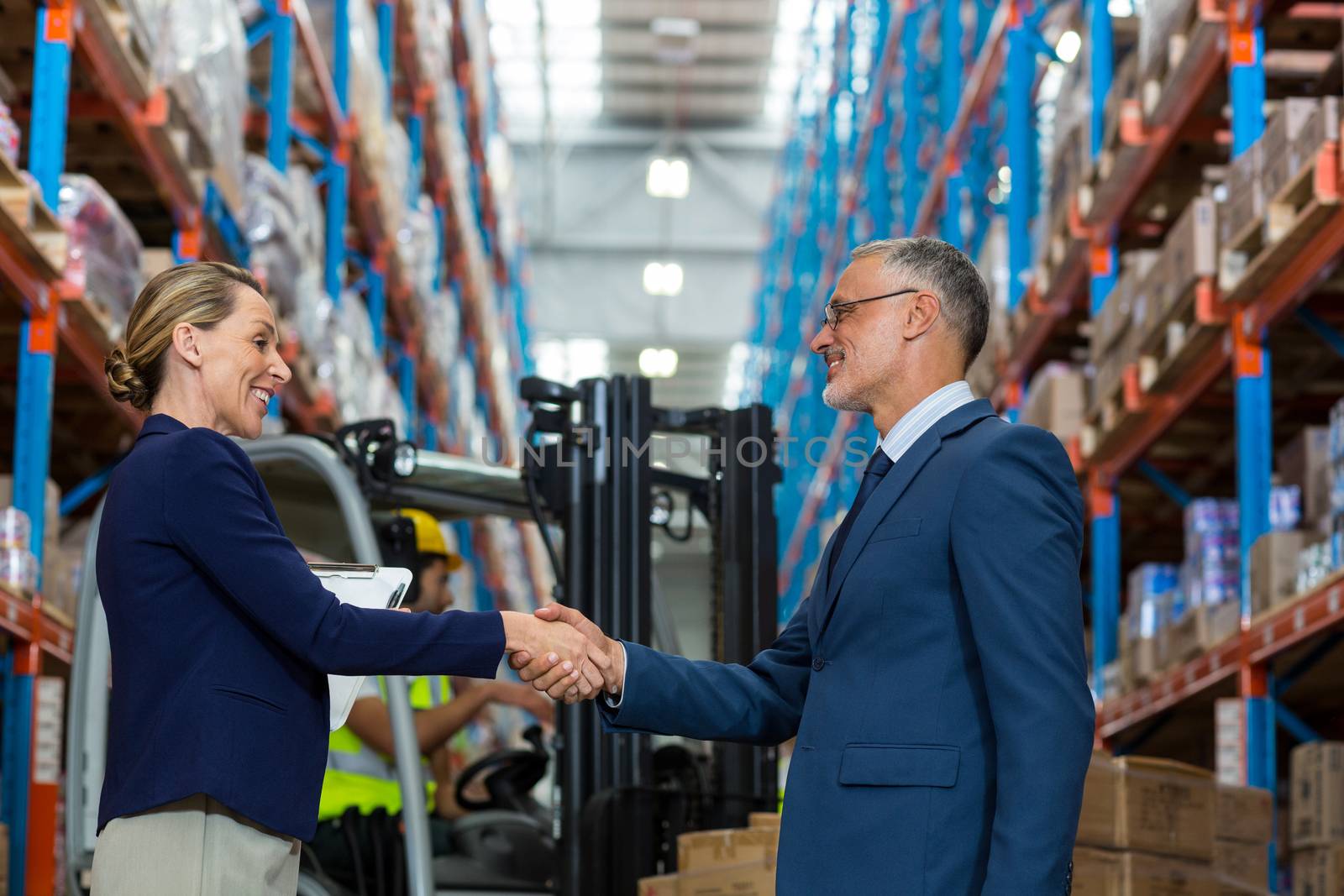 Business people are handshaking and smiling in a warehouse
