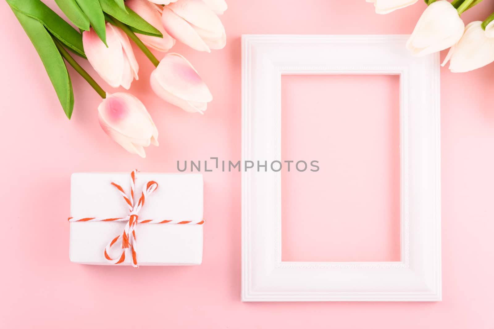 Happy Women's Day, Mother's Day concept. top view flat lay Tulip flower and photo frame on pink background, copy space for your text