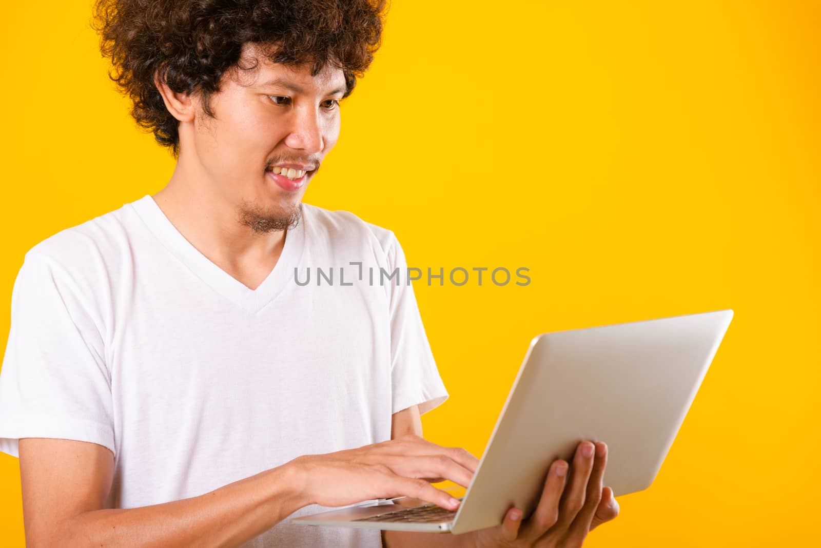 Asian handsome man with curly hair using laptop computer isolate by Sorapop