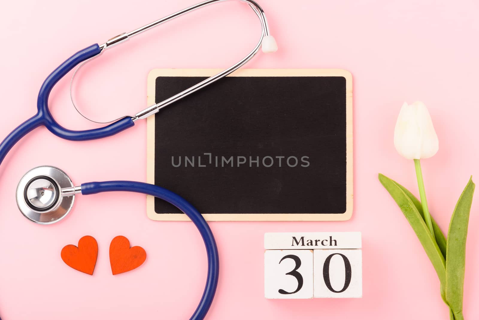 Doctor's Day concept, flat lay top view, equipment medical red heart stethoscope on pink background, care patient in hospital with black board copy space for text