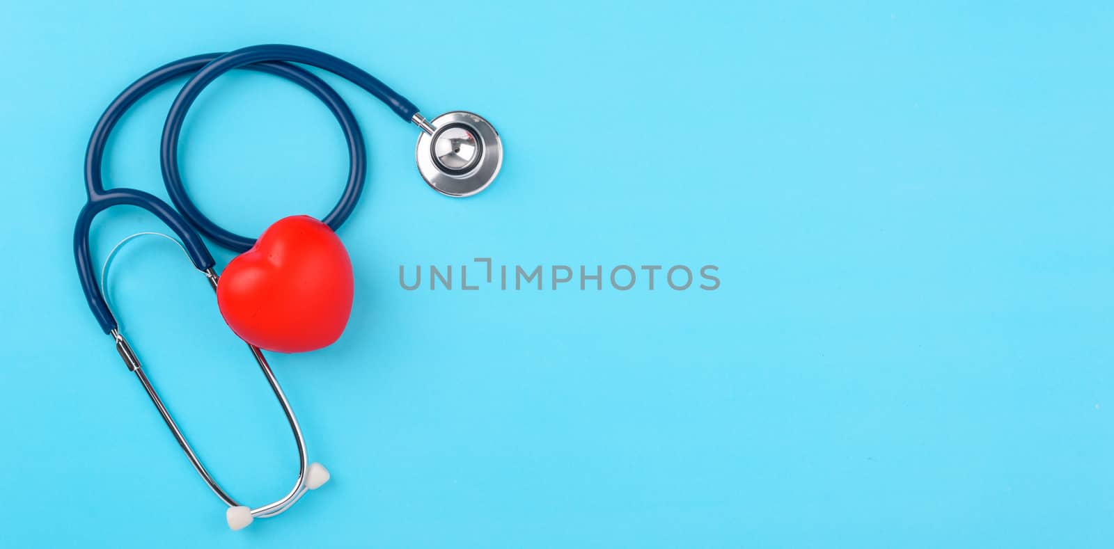 Doctor's Day concept, flat lay top view, stethoscope with red hearts diagnosis of heart disease on blue background with copy space for text