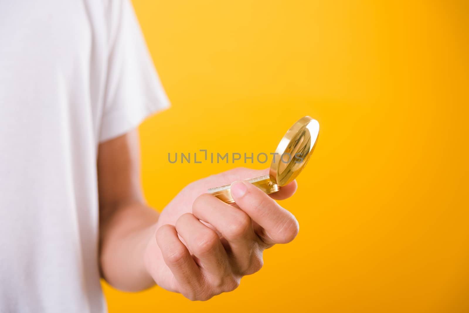 Hand holding antique brass compass isolated by Sorapop