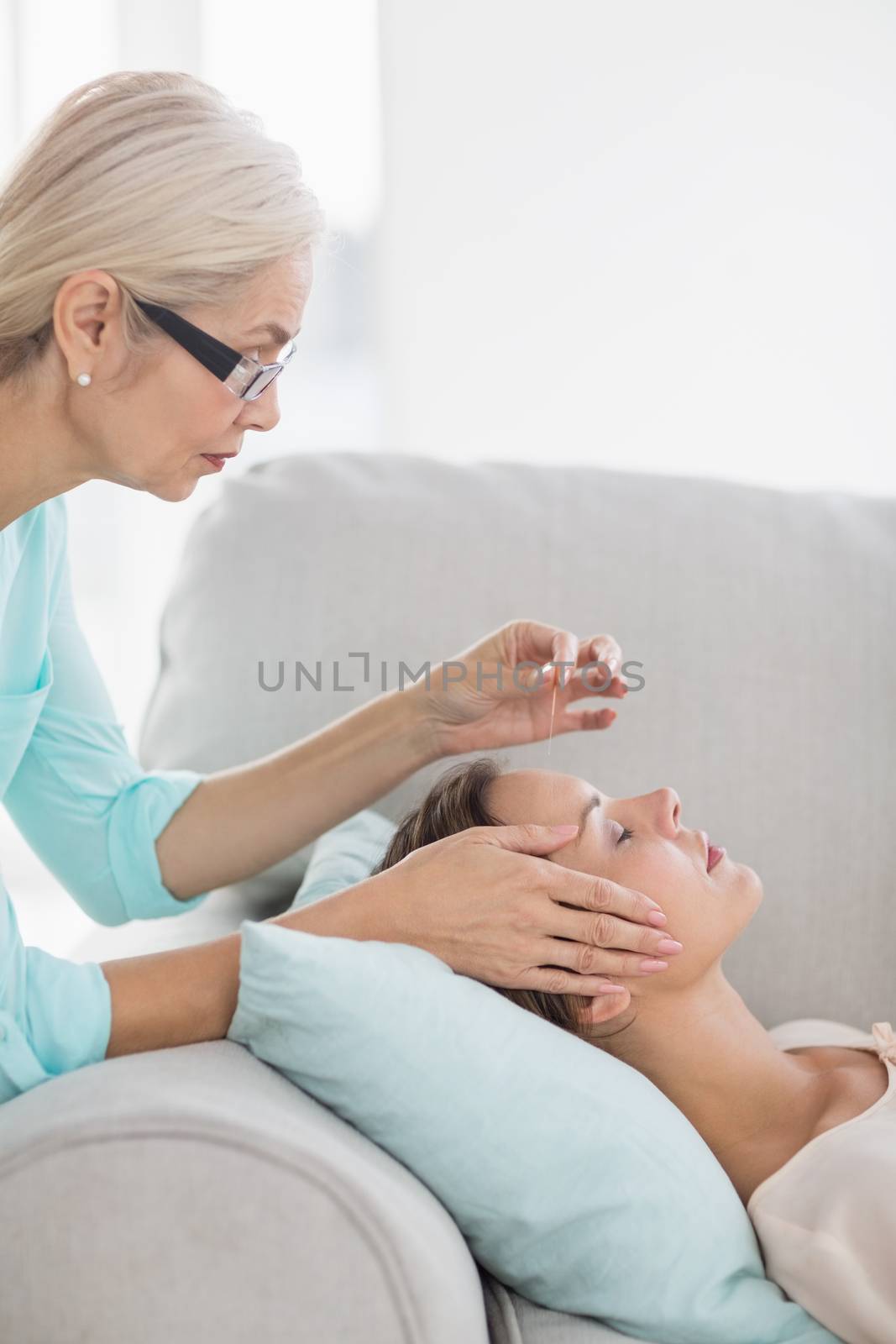 Woman receiving acupuncture treatment by Wavebreakmedia