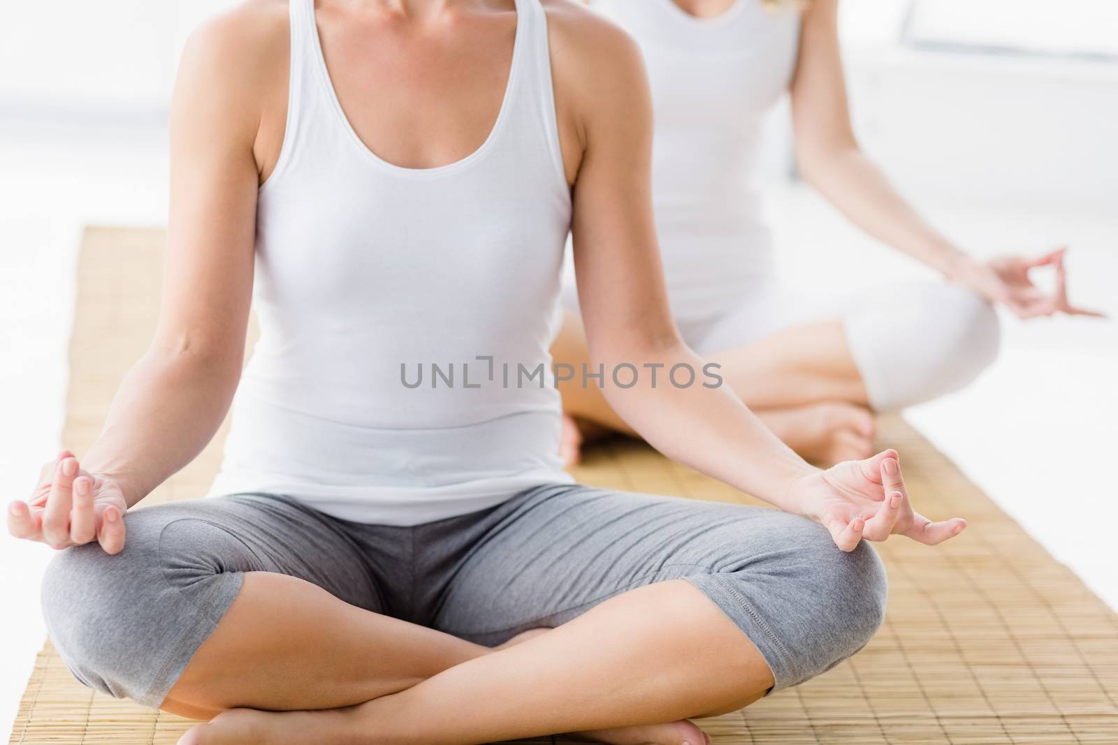 Women in lotus position doing yoga at health club