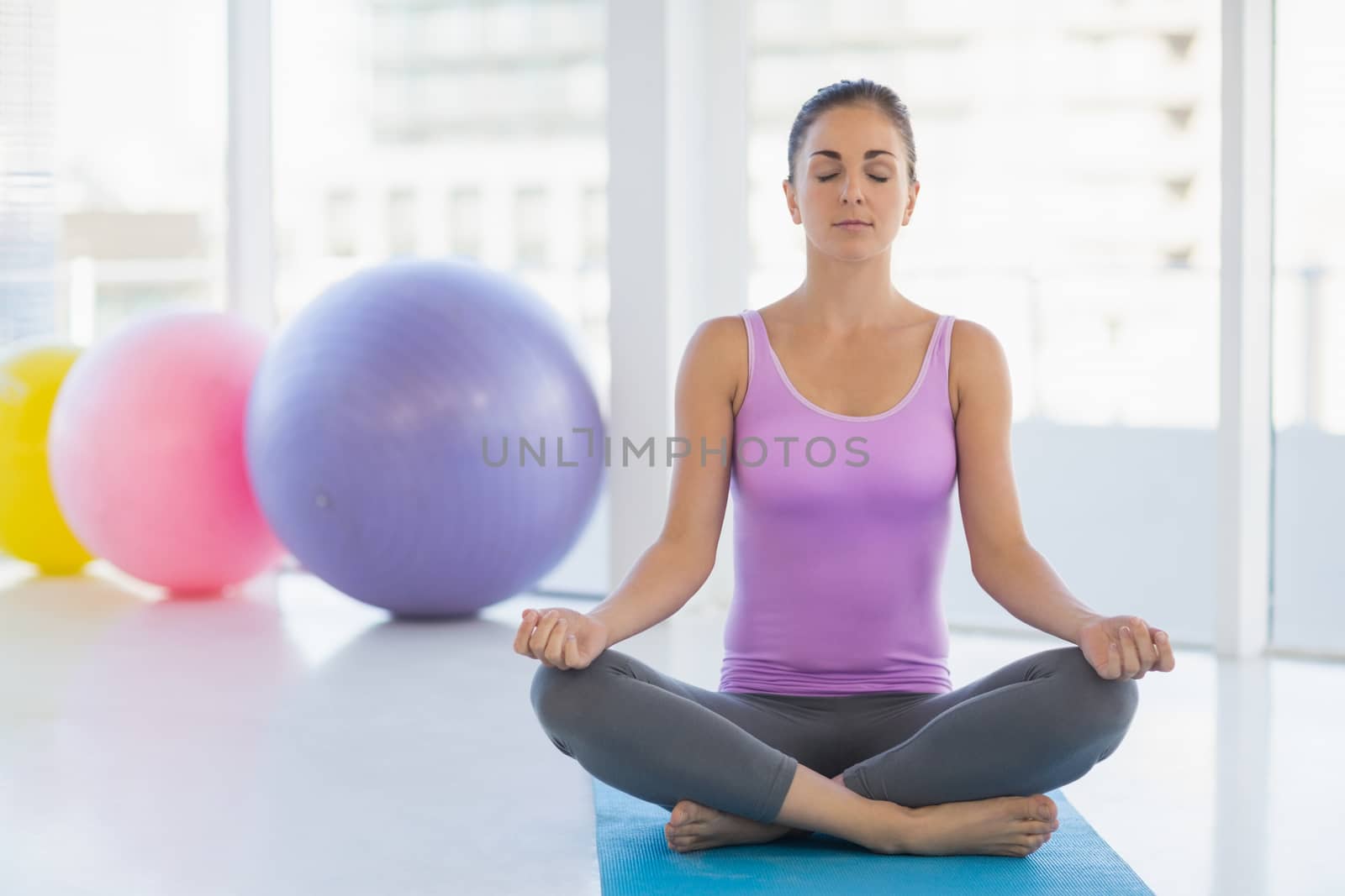 Full length of woman doing yoga at fitness studio