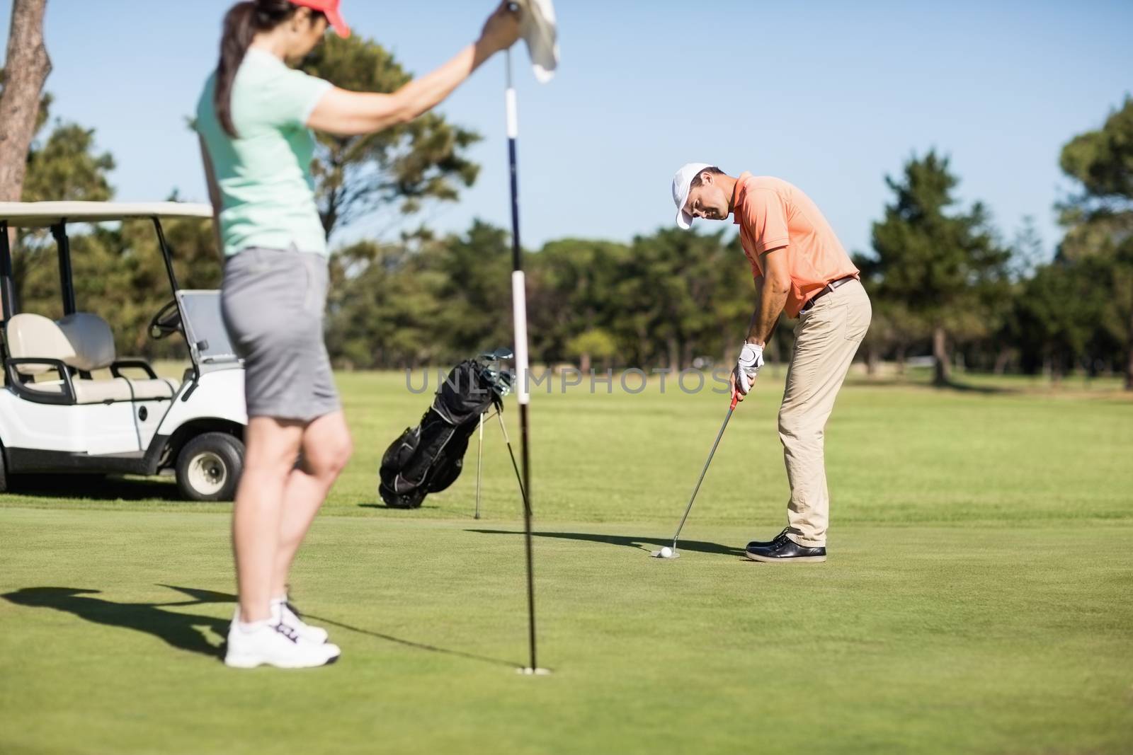 Couple playing golf together by Wavebreakmedia