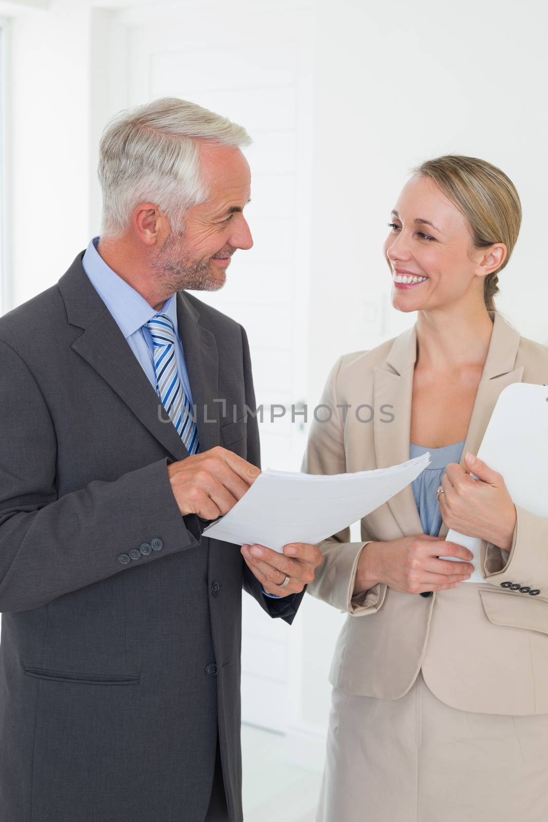 Smiling estate agent going over contract with customer in empty house