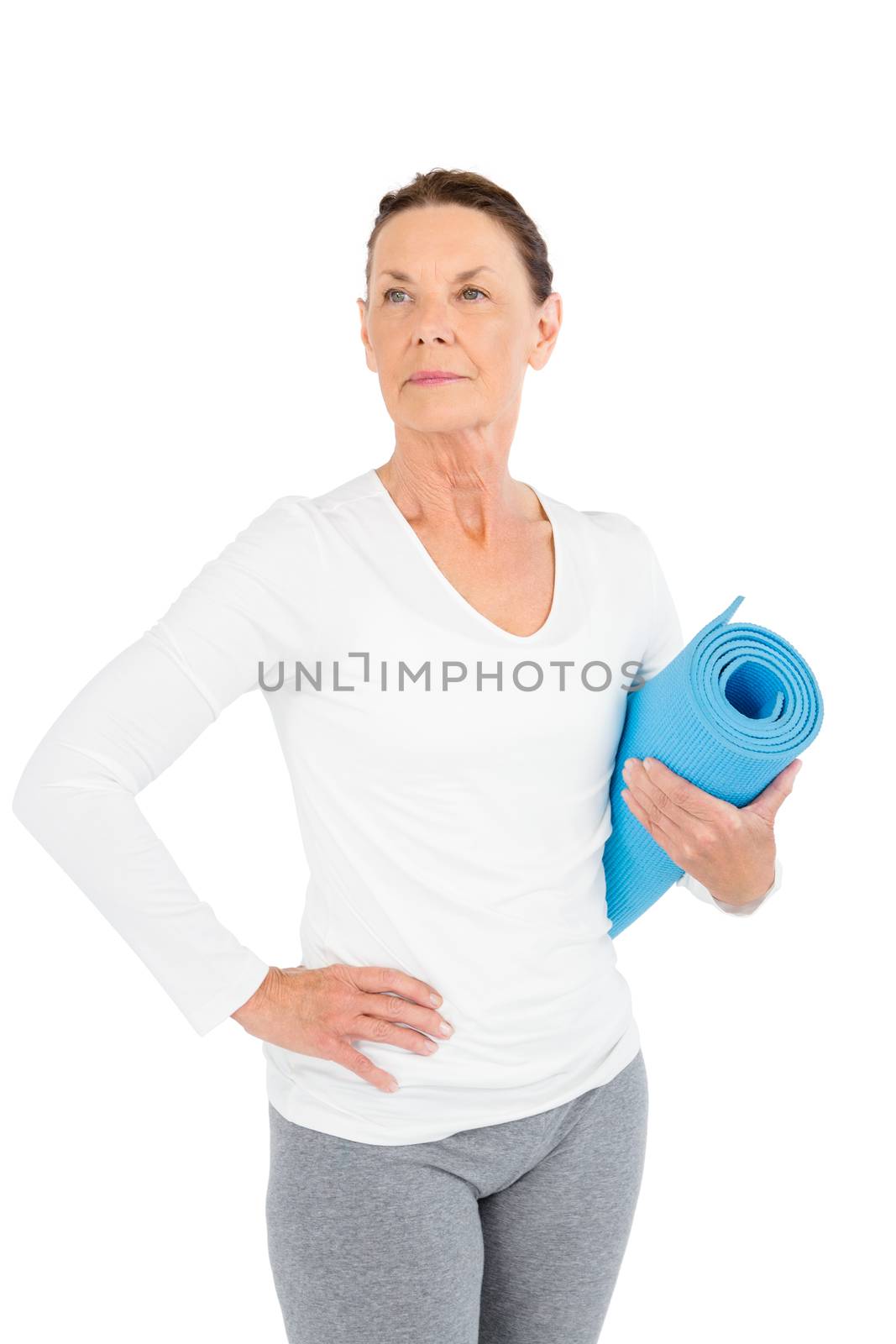 Mature woman holding exercise mat while standing on white background
