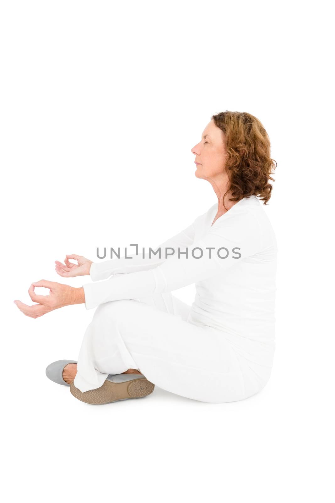 Side view of woman meditating against white background