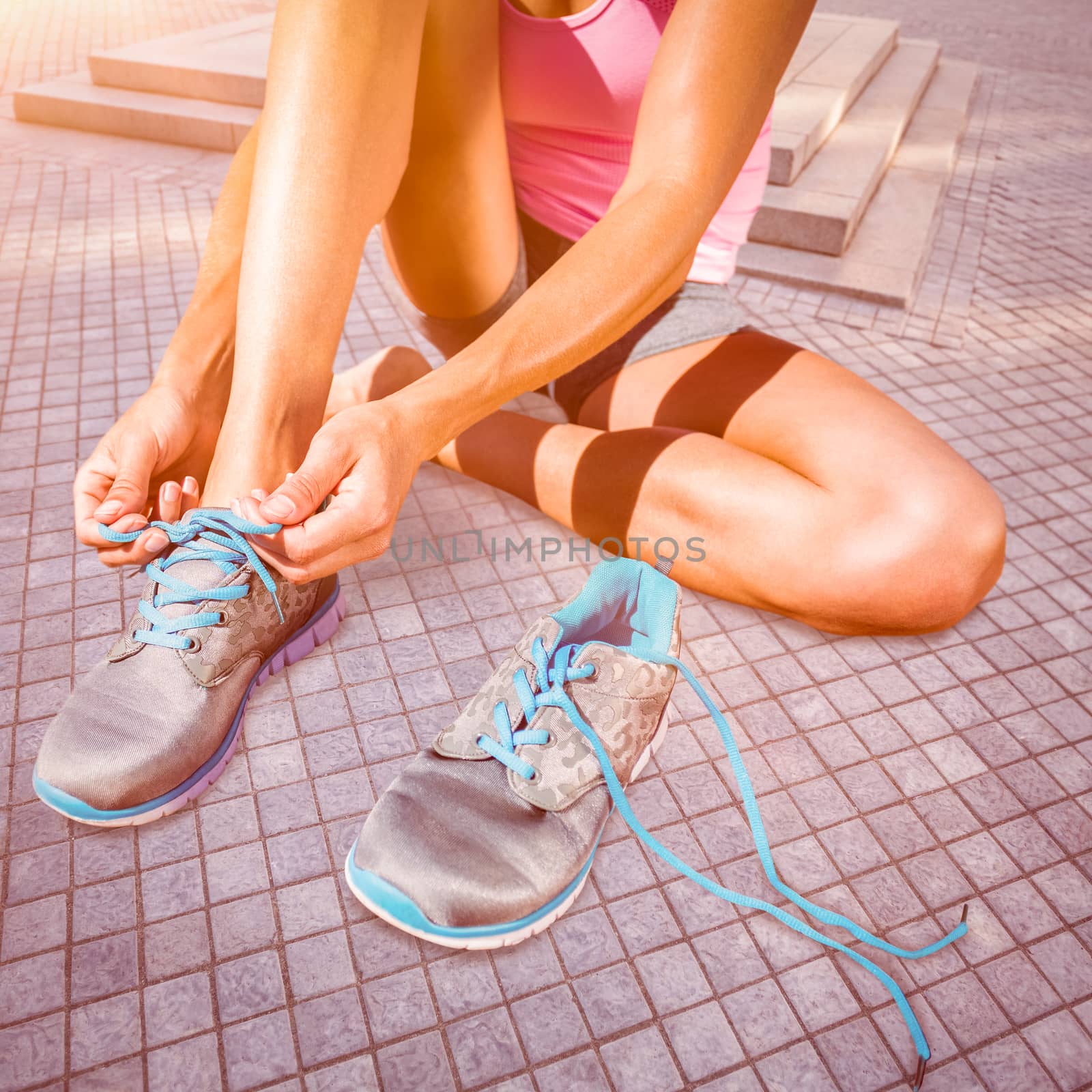 Composite image of athletic woman lacing up shoes