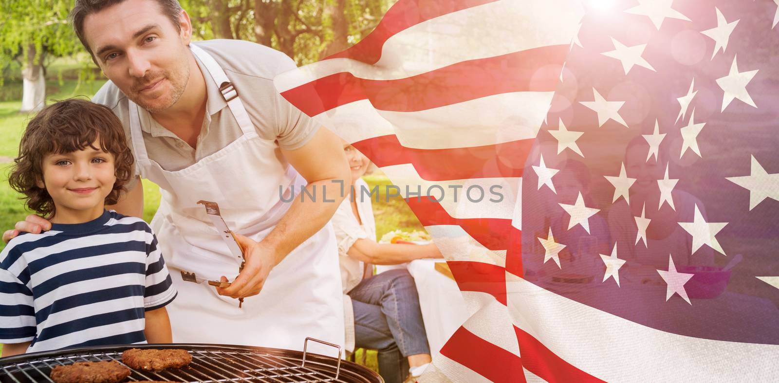 Composite image of father and son at barbecue grill with family having lunch in park by Wavebreakmedia