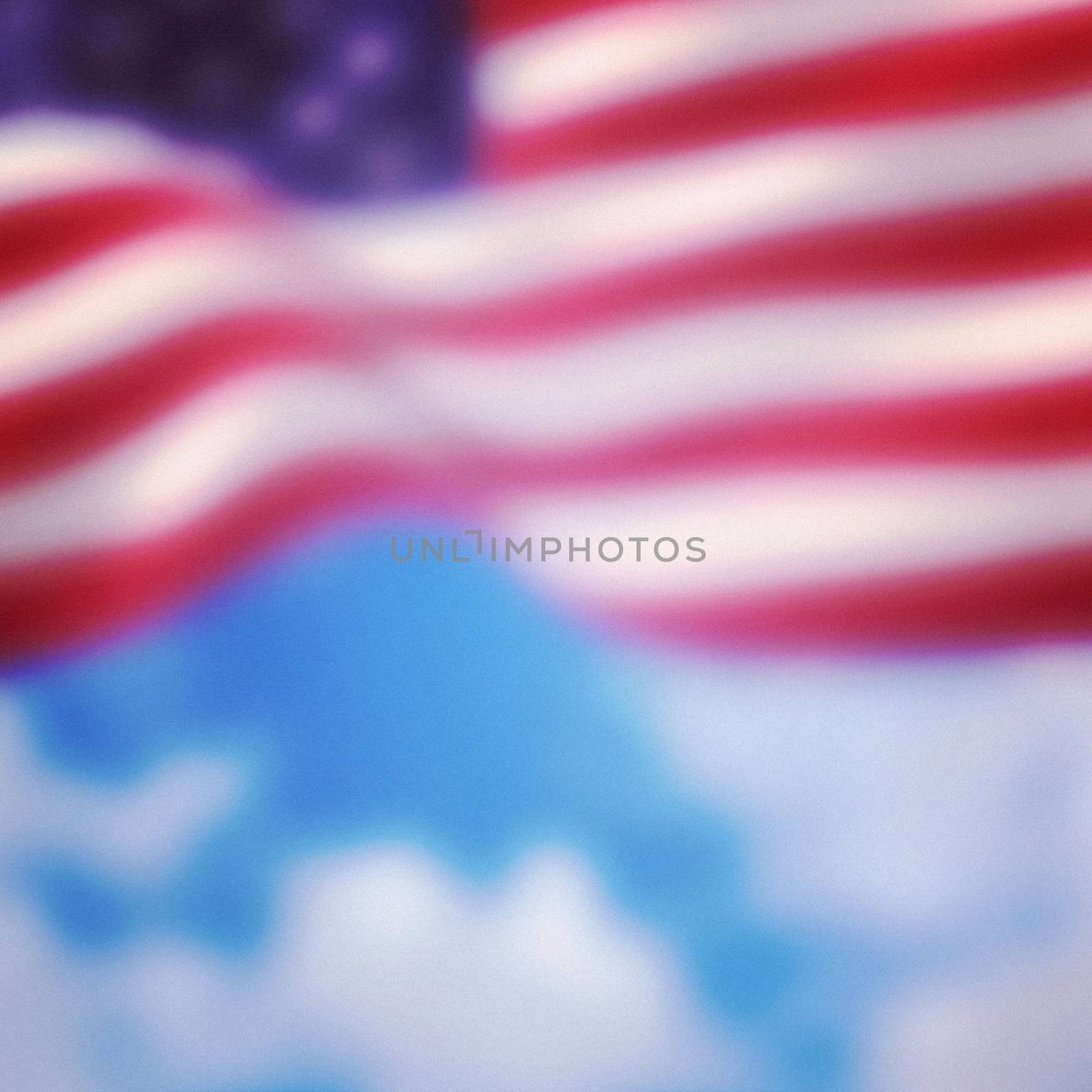 Close-up of American flag against cloudy sky background