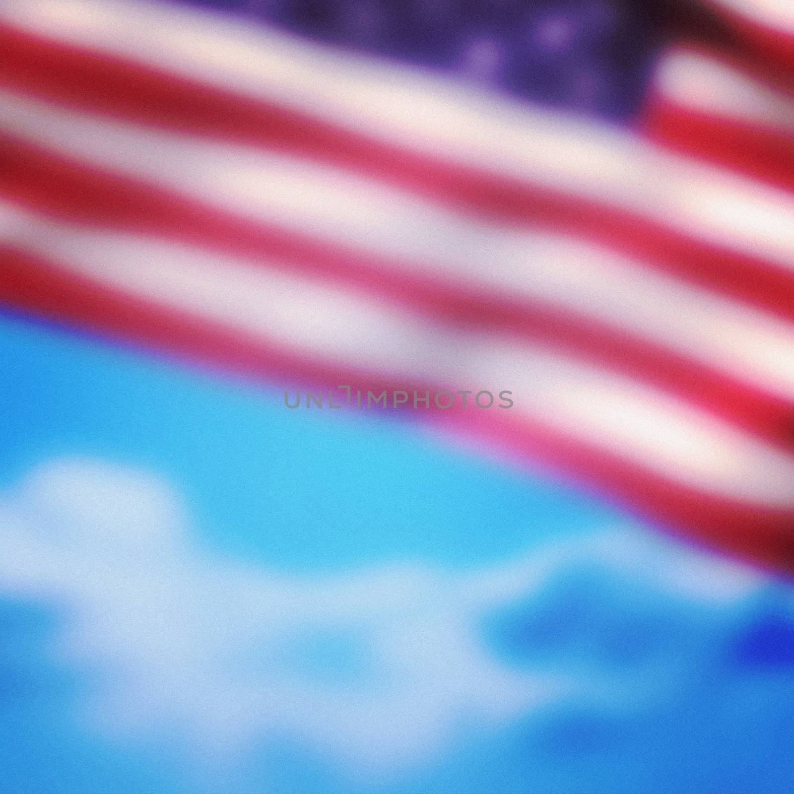 Close-up of American flag against cloudy sky background