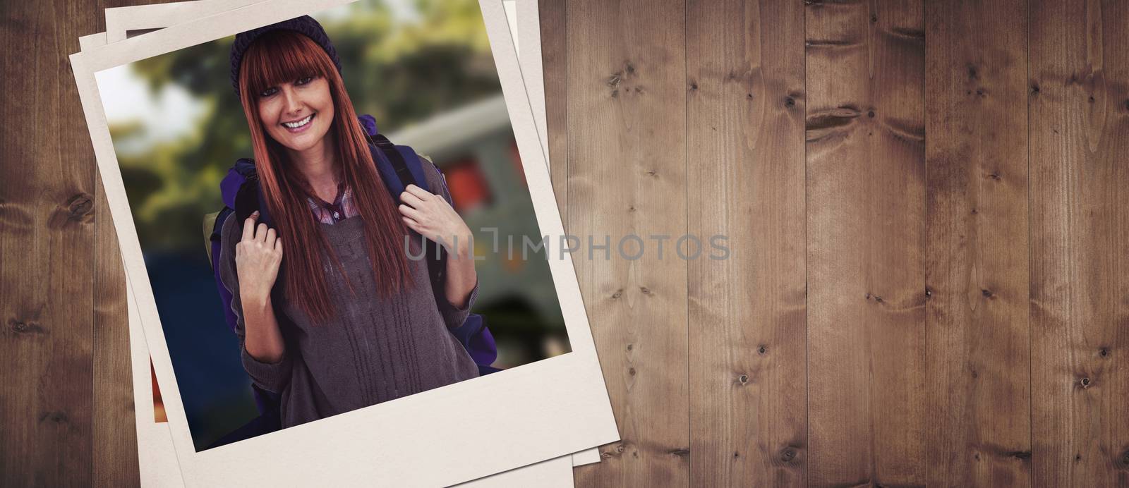 Side view of a hipster woman with a travel bag against wooden planks