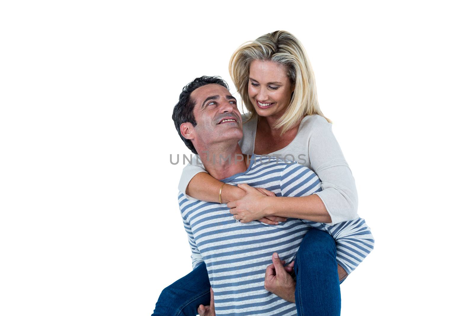 Romantic mid adult man carrying woman piggyback against white background