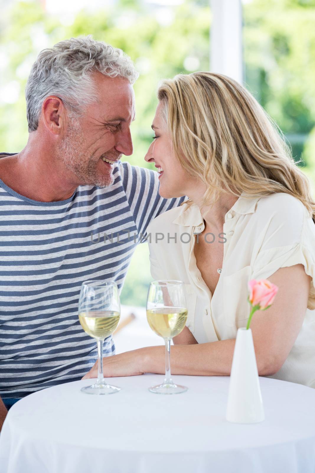 Romantic smiling mature couple with white wine by Wavebreakmedia