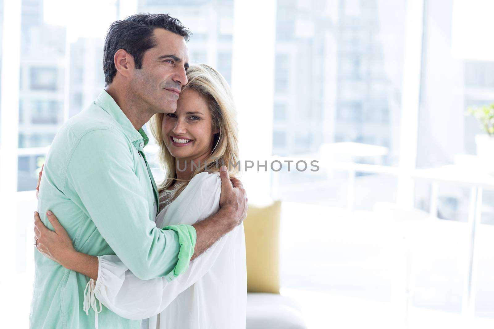 Mid adult romantic couple hugging at home