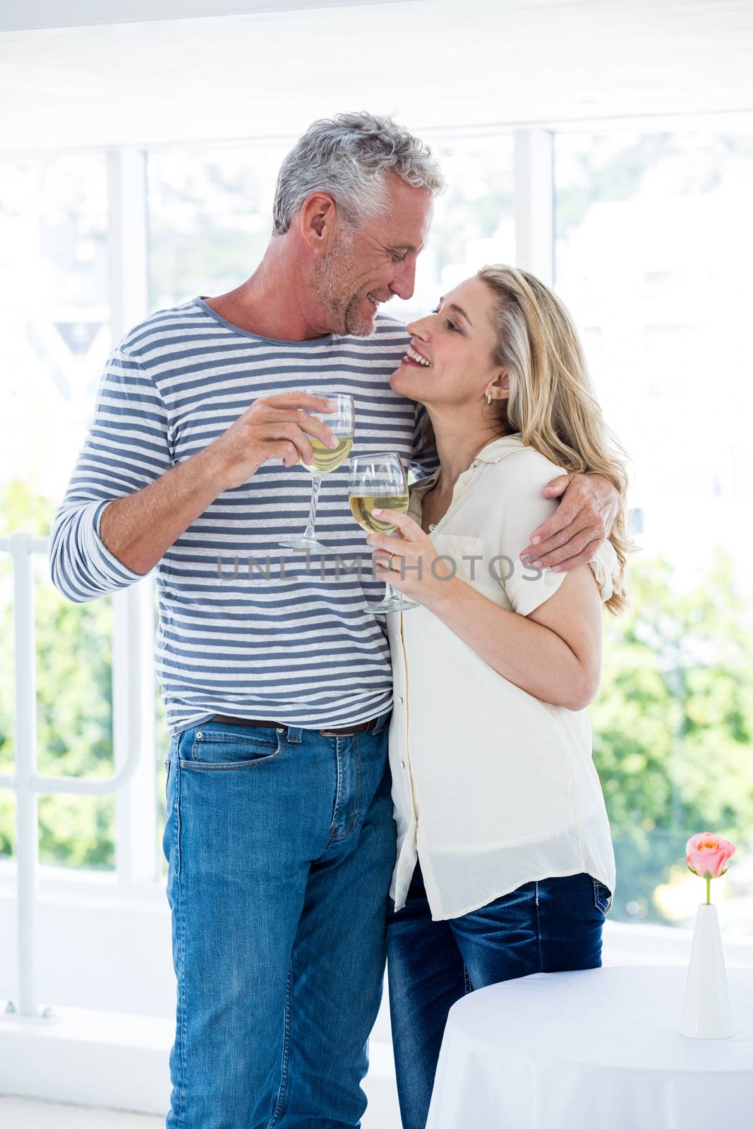 Romantic mature couple with wine glasses while sitting at restaurant