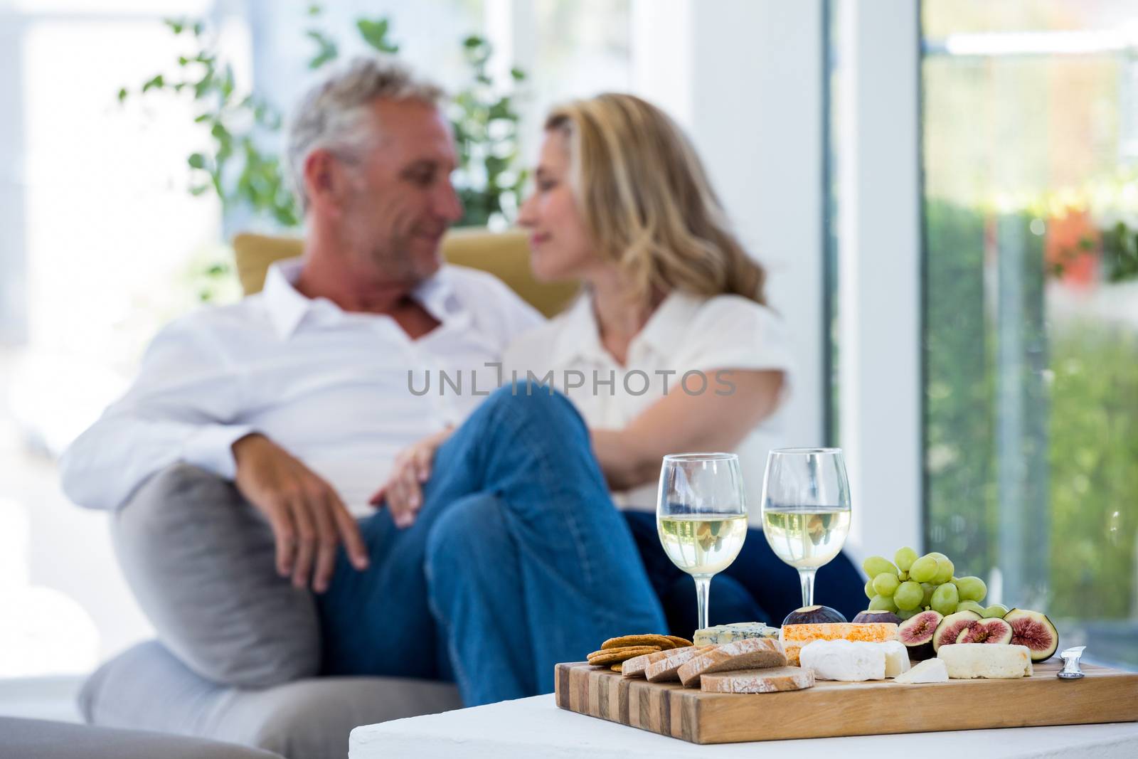 White wine and food on table with romantic couple in background