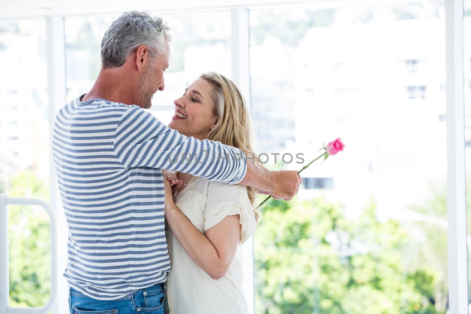 Romantic mature couple embracing while standing at restaurant