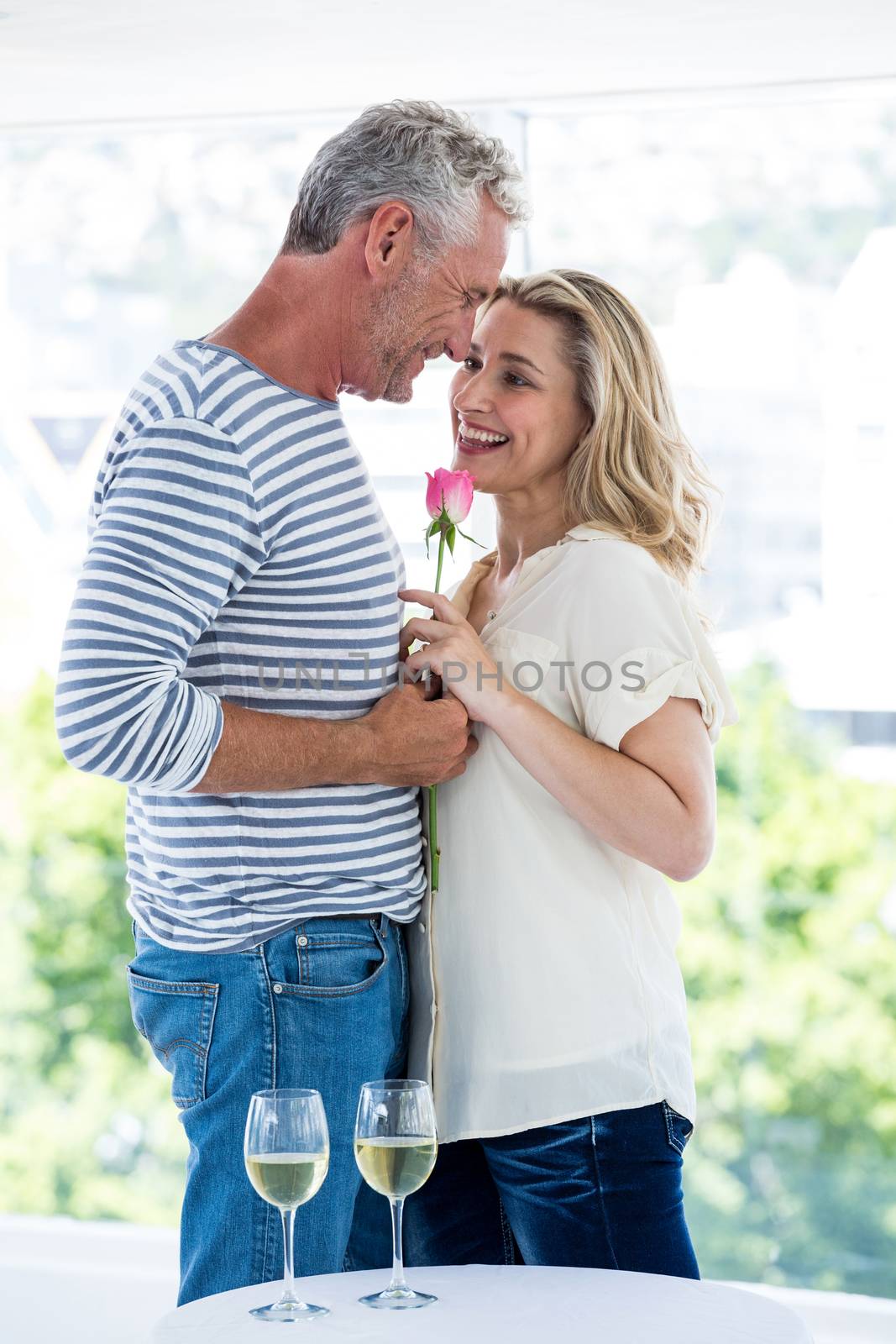 Romantic mature couple with pink rose  by Wavebreakmedia